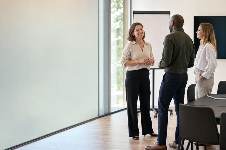 A facilitator with two colleagues at the front of a training room